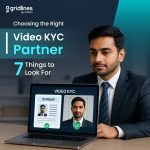 A professional man in a suit sits at a desk with a laptop showing a Video KYC process; the screen displays an ID proof and a live face match with green checkmarks.